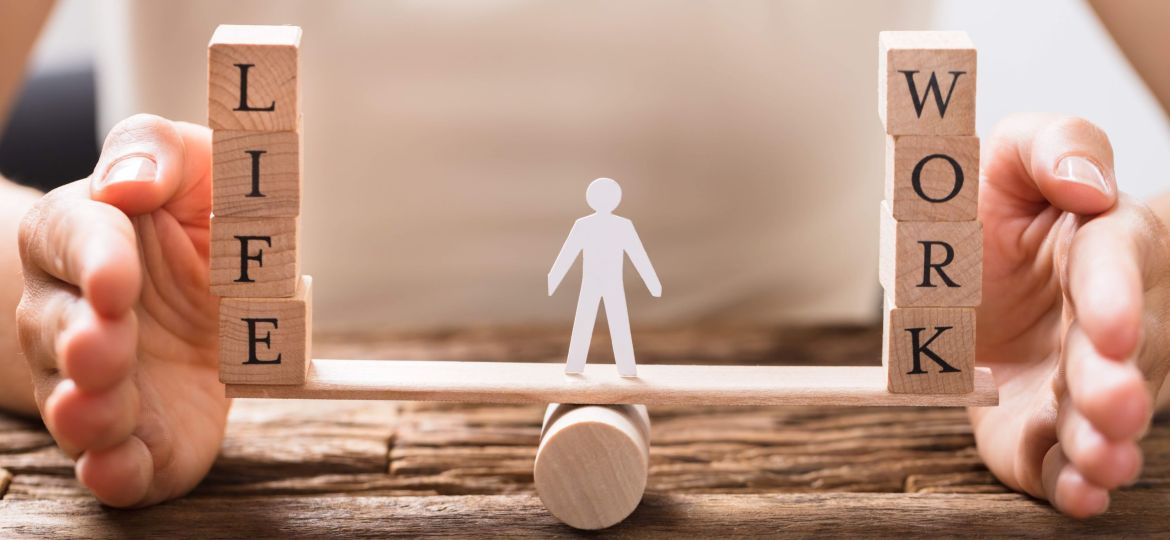 Close-up Of A Human Hand Protecting Balance Between Life And Work On Seesaw