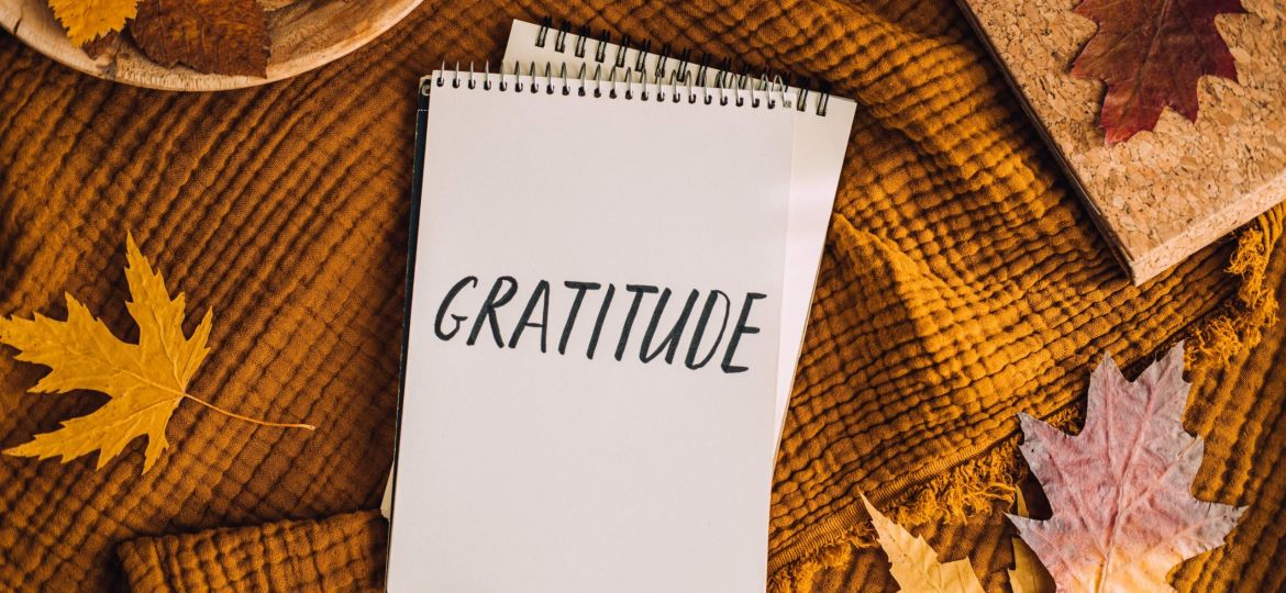 How to Practice Gratitude. Writing Autumn fall gratitude journal. Open paper notebook pages with Text gratitude and fall leaves brown bed. Notice appreciate good things, Express gratitude to yourself.