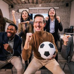 group of office workers cheering on soccer