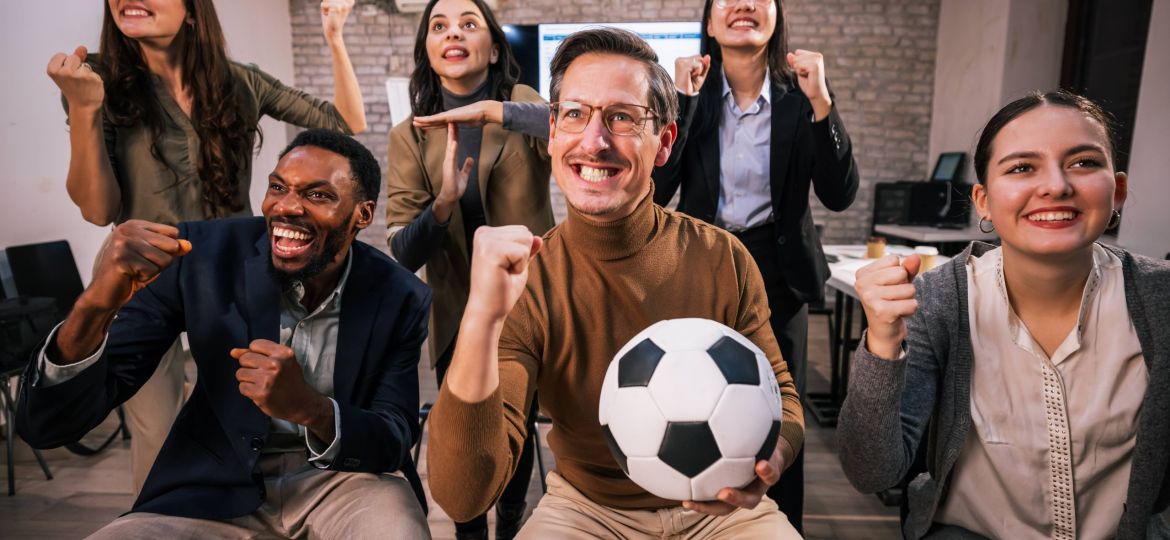 group of office workers cheering on soccer